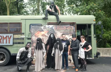 green bus srrounded by actors portraying zombies