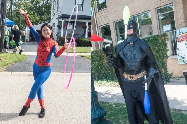 woman in spider-man costume juggling hoops and man in batman costume juggling bowling pins